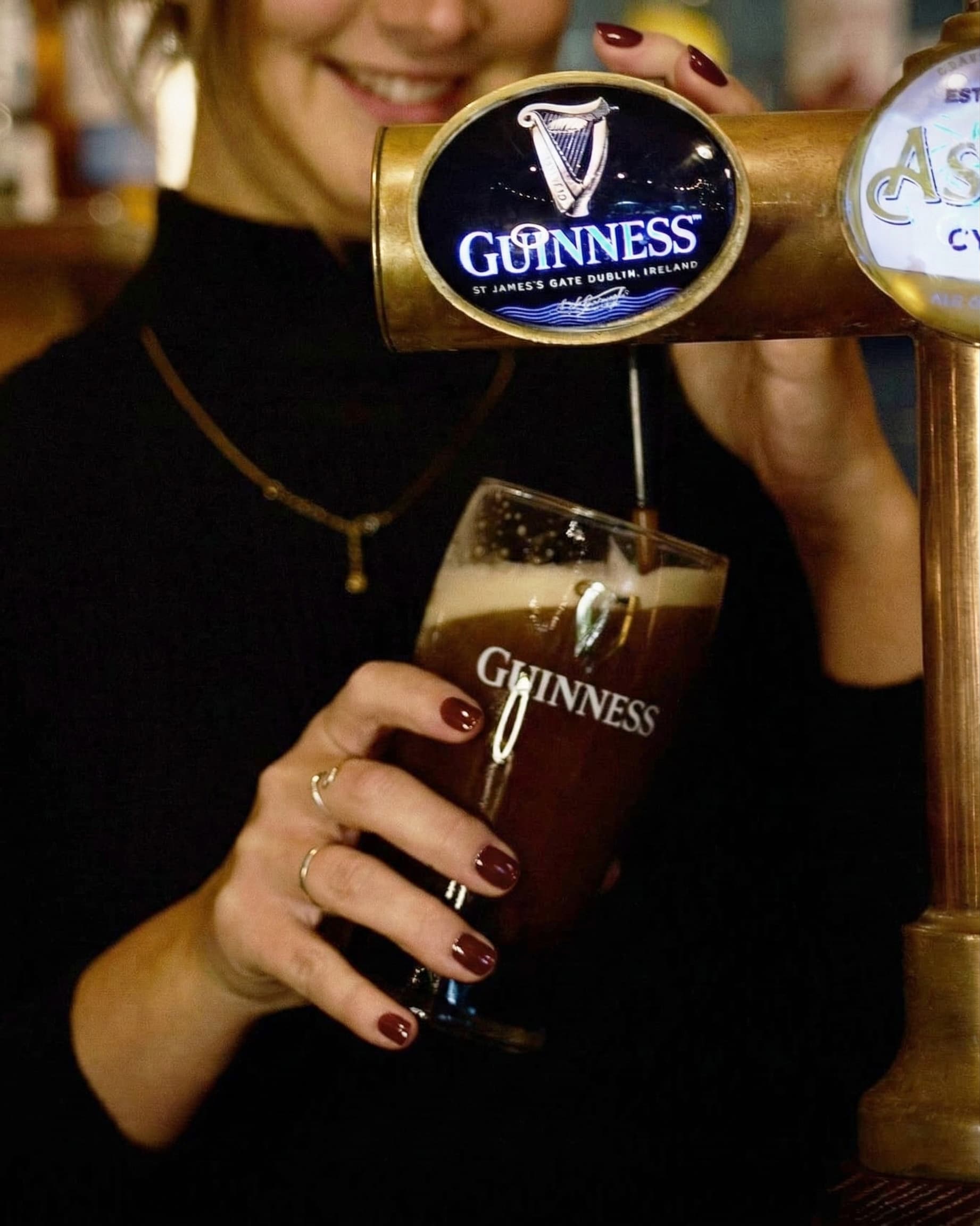 Bartender pouring a pint of Guinness at a Barons pub on St Patrick's Day